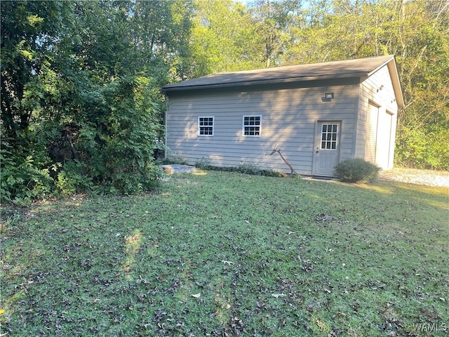 view of side of property featuring a lawn and an outdoor structure