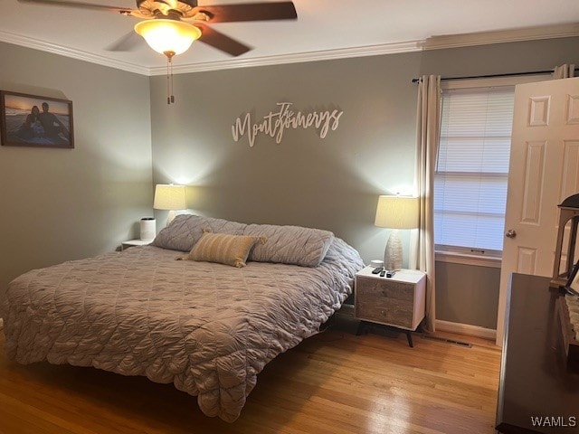 bedroom with hardwood / wood-style flooring, ceiling fan, and ornamental molding