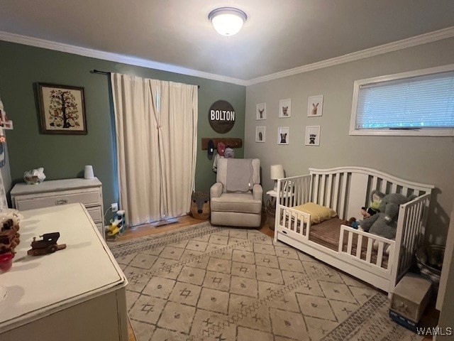 bedroom with a nursery area and ornamental molding