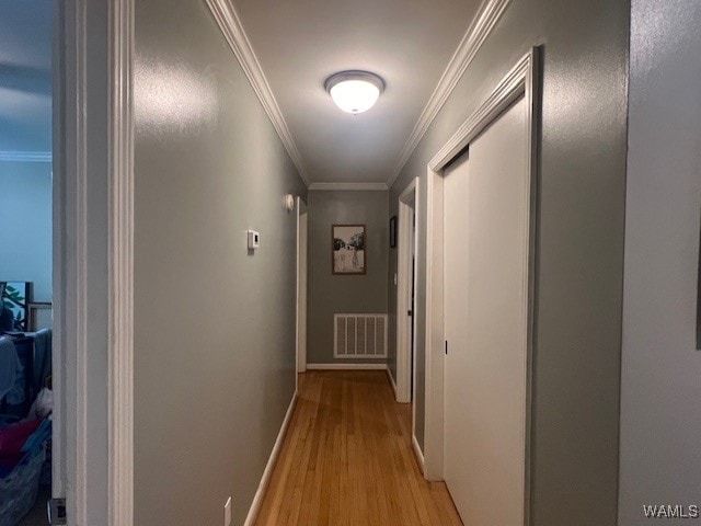 hallway featuring crown molding and light hardwood / wood-style floors