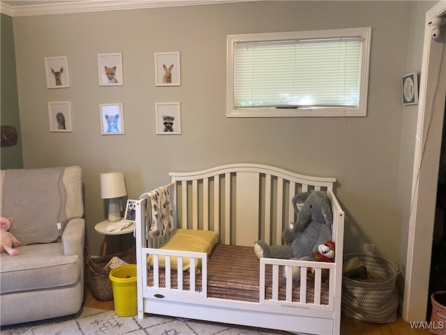 bedroom featuring a crib and ornamental molding