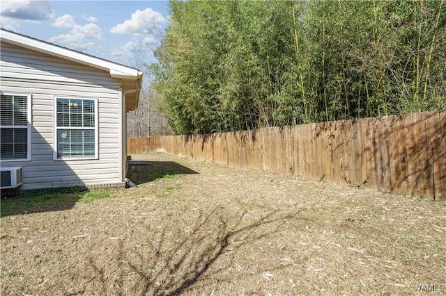 view of yard with central air condition unit and a fenced backyard