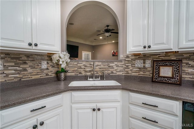 kitchen featuring dark countertops, ceiling fan, white cabinetry, and a sink