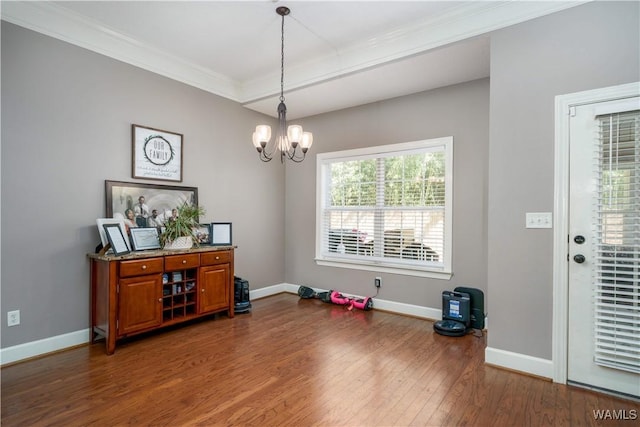 dining space featuring dark wood-style floors, ornamental molding, a notable chandelier, and baseboards