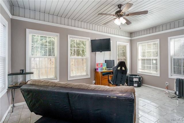 living area featuring ornamental molding, plenty of natural light, baseboards, and ceiling fan