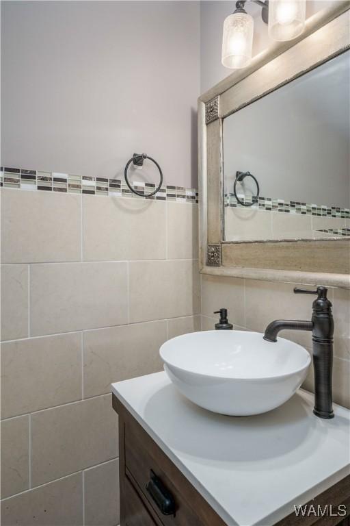 bathroom with vanity and tile walls