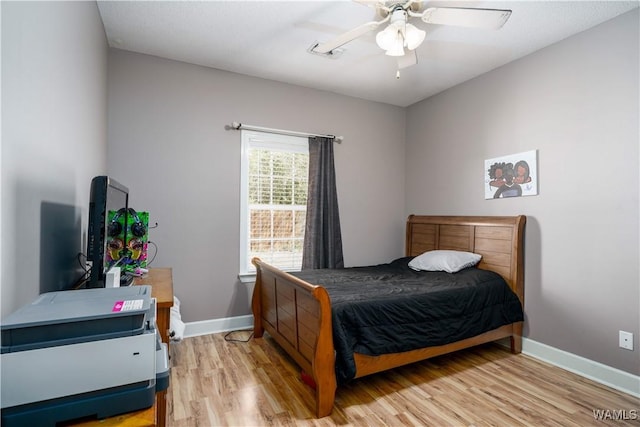 bedroom with light wood-style flooring, baseboards, and ceiling fan