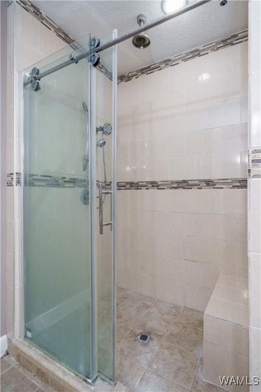 full bathroom with tile patterned flooring and a shower stall