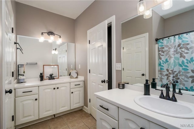 full bathroom featuring curtained shower, tile patterned flooring, two vanities, and a sink