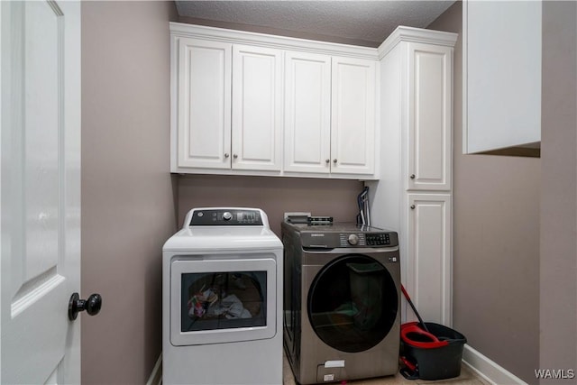 washroom with independent washer and dryer, cabinet space, and baseboards