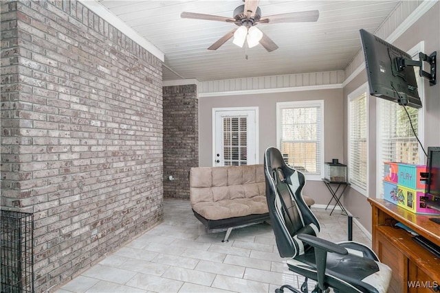 office space with ceiling fan, brick wall, baseboards, and crown molding