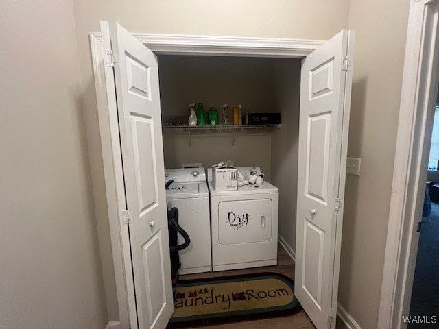 laundry room featuring washing machine and dryer and hardwood / wood-style flooring