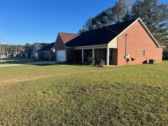 view of front of property with central AC unit, a garage, and a front yard