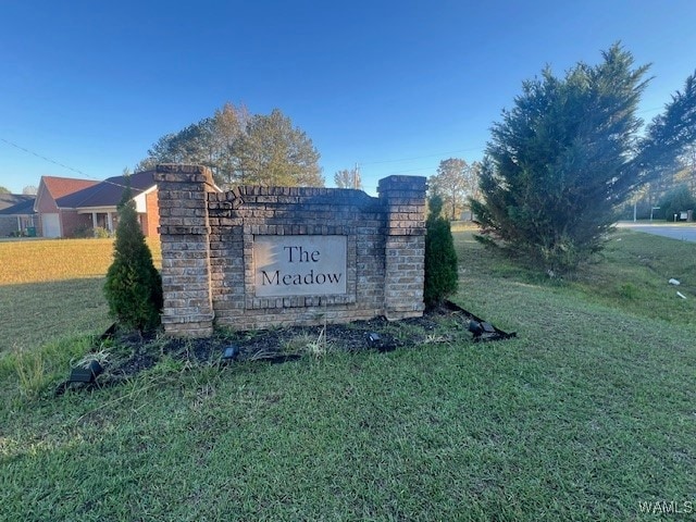 community / neighborhood sign featuring a yard