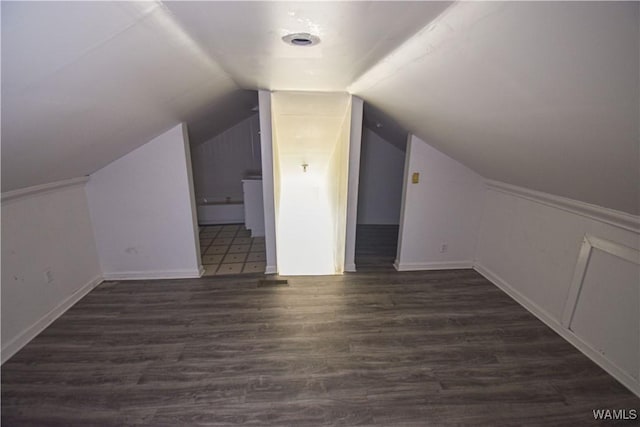 bonus room with dark hardwood / wood-style floors and vaulted ceiling