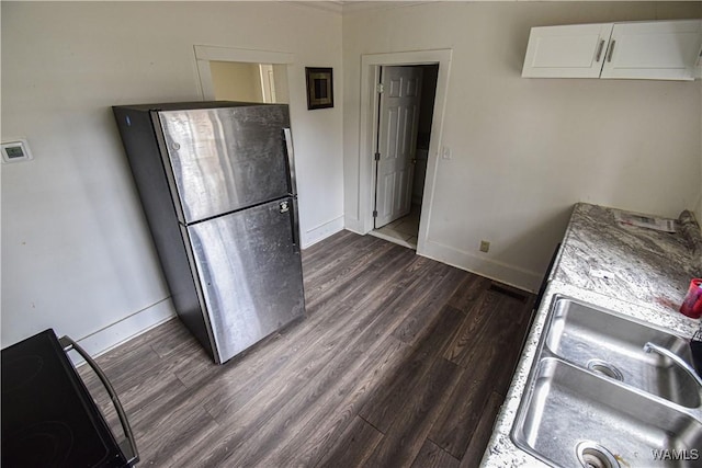 kitchen with sink, stainless steel fridge, white cabinetry, electric range, and dark hardwood / wood-style flooring