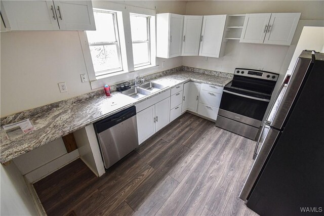 kitchen with white cabinetry, sink, dark hardwood / wood-style flooring, stainless steel appliances, and light stone countertops