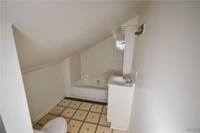 bathroom with lofted ceiling, toilet, and vanity