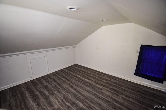 bonus room featuring vaulted ceiling and dark wood-type flooring