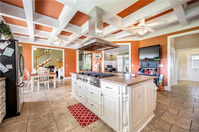 kitchen featuring island exhaust hood, stainless steel appliances, beamed ceiling, white cabinets, and a center island