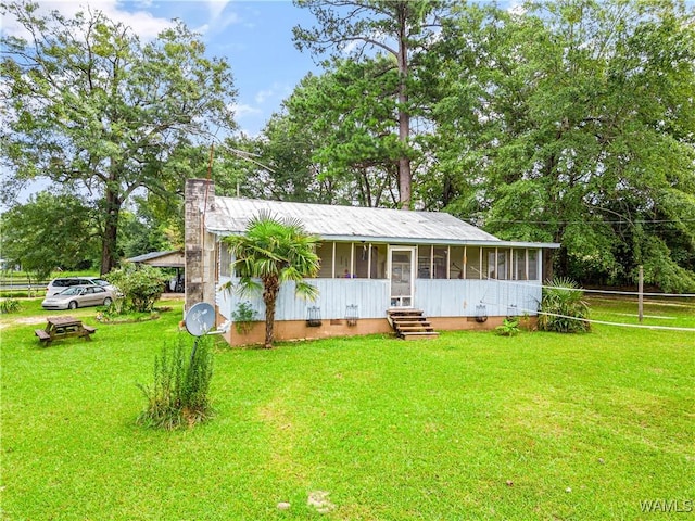 ranch-style house with a sunroom and a front lawn