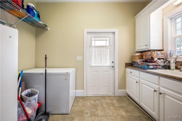 laundry room featuring cabinets, washer and clothes dryer, and sink