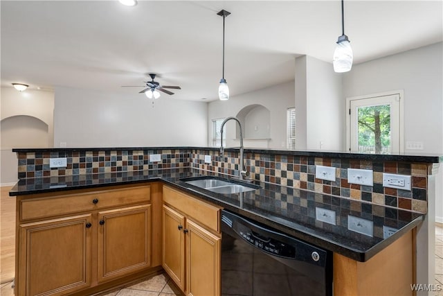 kitchen with a sink, black dishwasher, hanging light fixtures, backsplash, and brown cabinets