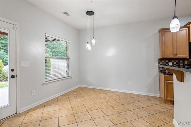 unfurnished dining area with light tile patterned flooring, visible vents, and baseboards