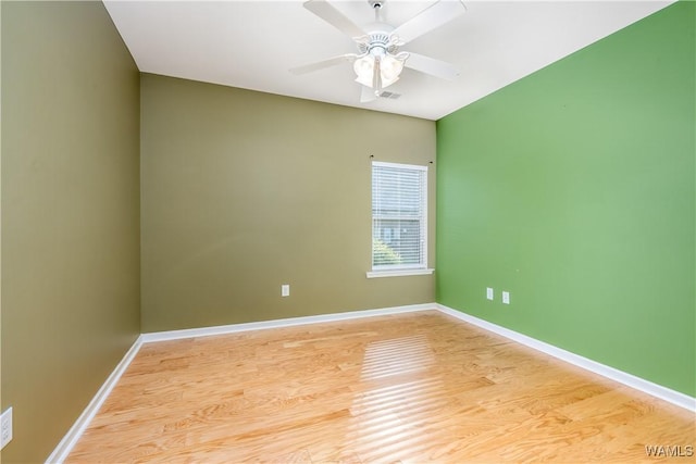 unfurnished room featuring baseboards, a ceiling fan, visible vents, and light wood-style floors