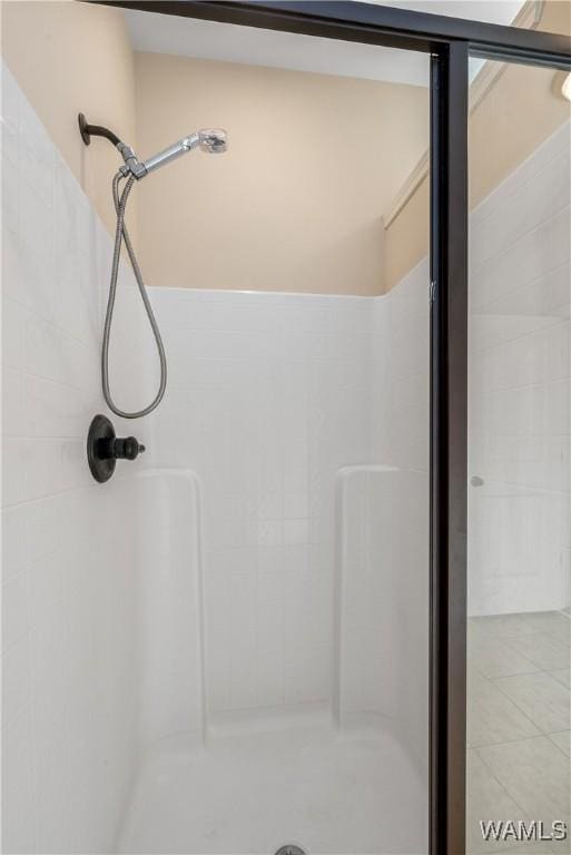 bathroom with tile patterned flooring and a shower stall