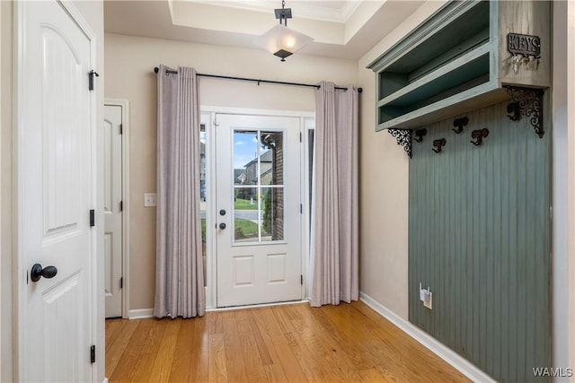 entryway featuring crown molding, light wood-style flooring, and baseboards