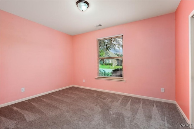 empty room featuring carpet, visible vents, and baseboards