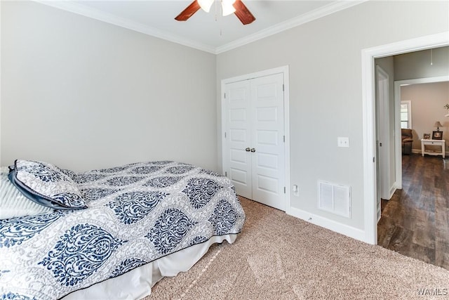 carpeted bedroom featuring a closet, ceiling fan, and crown molding