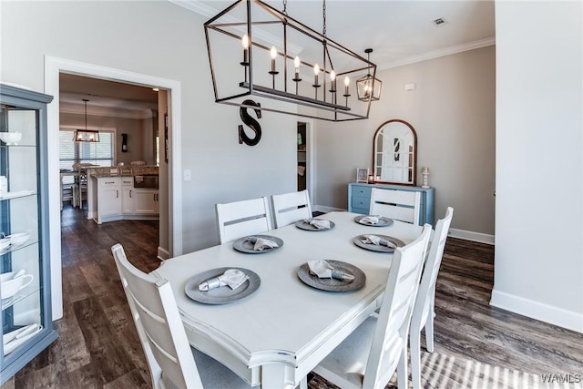 dining area featuring a notable chandelier, dark wood-type flooring, and crown molding