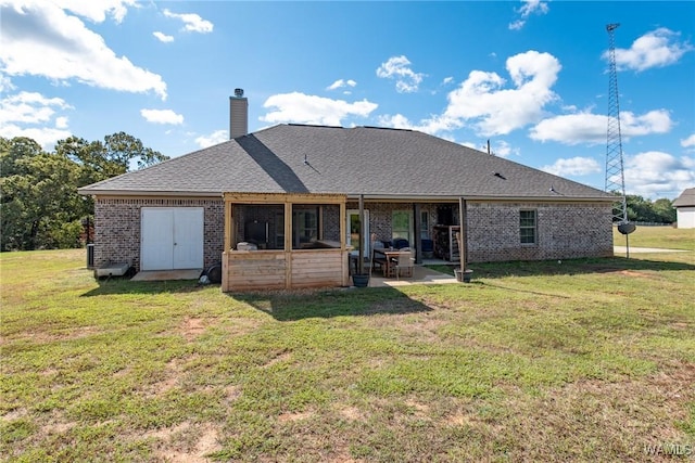 rear view of property with a patio and a lawn