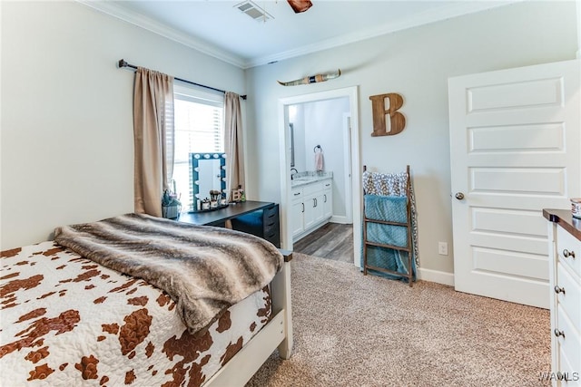 bedroom with connected bathroom, ornamental molding, and carpet