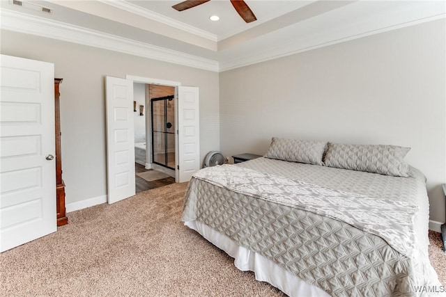 carpeted bedroom with ensuite bath, ceiling fan, a tray ceiling, and ornamental molding