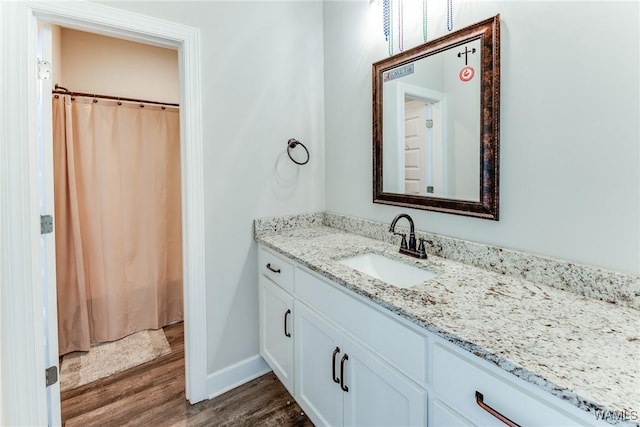 bathroom featuring walk in shower, hardwood / wood-style floors, and vanity