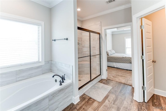 bathroom with ornamental molding, separate shower and tub, and hardwood / wood-style floors