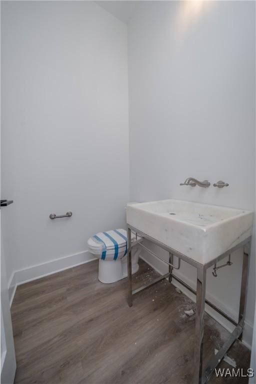 bathroom with toilet and wood-type flooring