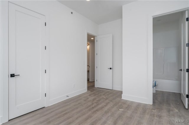 unfurnished bedroom featuring light wood-type flooring and a closet