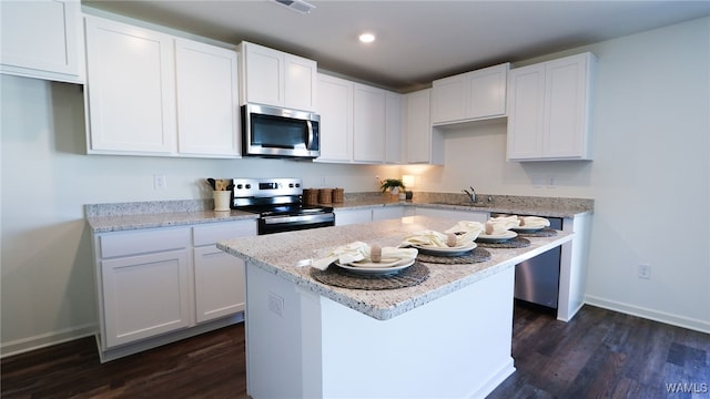 kitchen featuring white cabinets, stainless steel appliances, and dark hardwood / wood-style floors