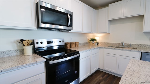 kitchen featuring light stone countertops, dark hardwood / wood-style flooring, stainless steel appliances, sink, and white cabinets