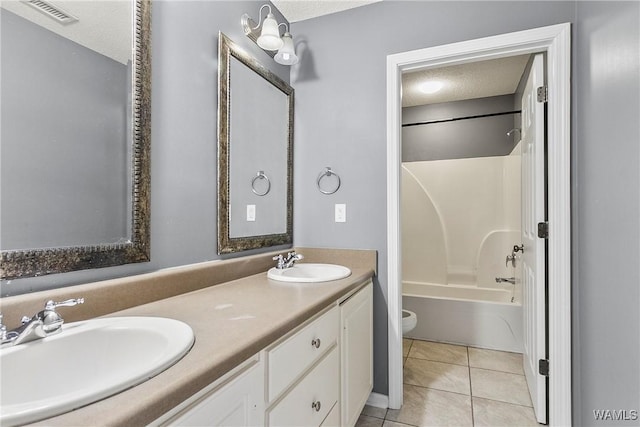 full bathroom featuring tile patterned flooring, vanity, a textured ceiling, shower / bathtub combination, and toilet