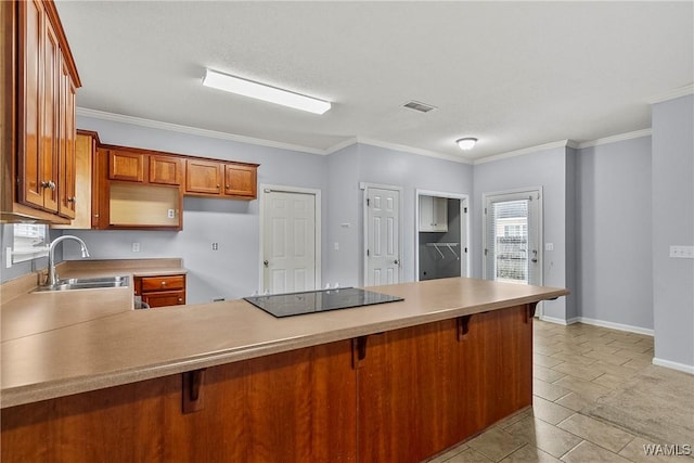 kitchen featuring black electric stovetop, a kitchen bar, kitchen peninsula, and sink