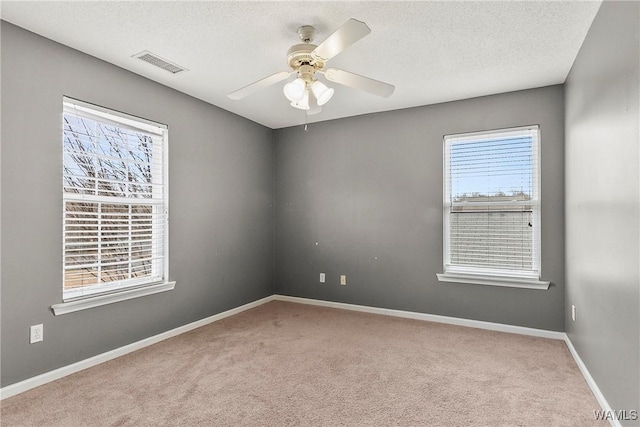 carpeted spare room featuring ceiling fan and a textured ceiling