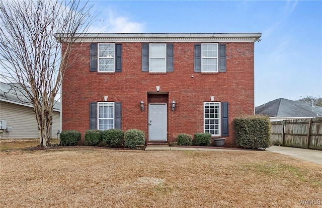 colonial-style house featuring a front yard