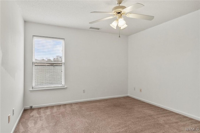 carpeted spare room with ceiling fan and a textured ceiling