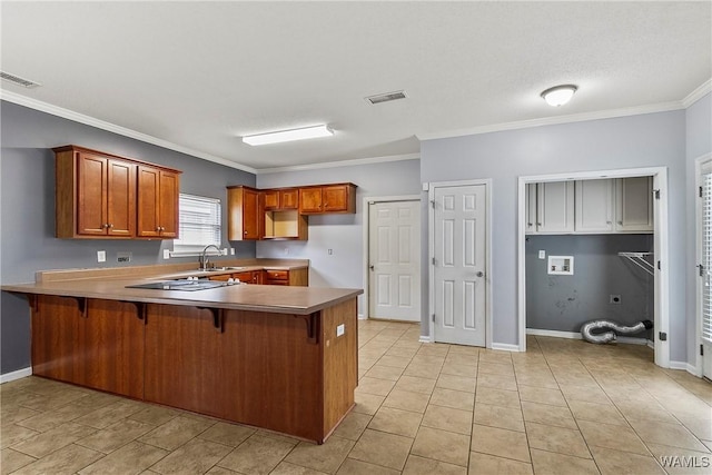 kitchen with sink, crown molding, a kitchen breakfast bar, kitchen peninsula, and black electric stovetop