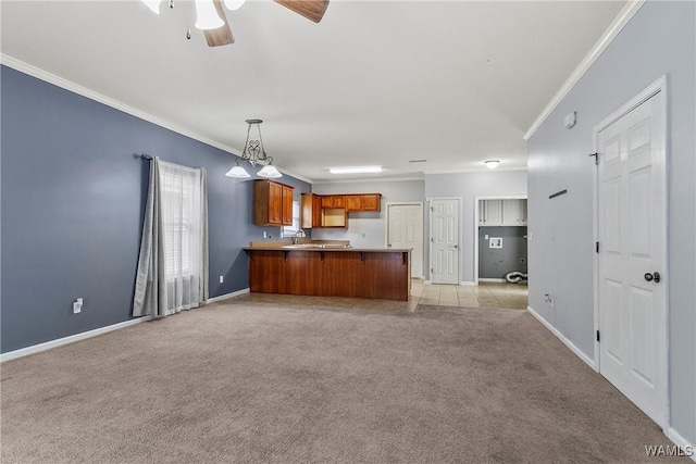 kitchen with pendant lighting, crown molding, ceiling fan, light colored carpet, and kitchen peninsula